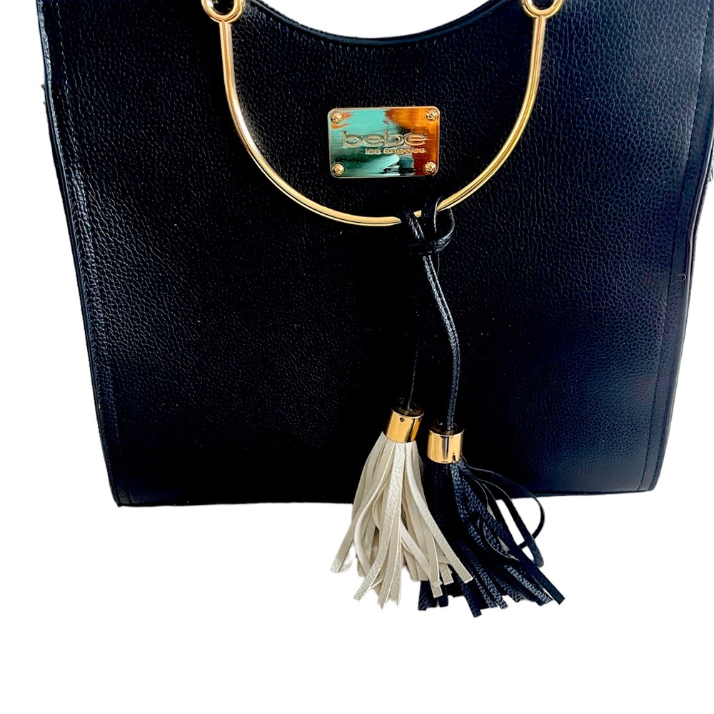 Bebe woman’s handbag. Black leather with tassels, gold handles.